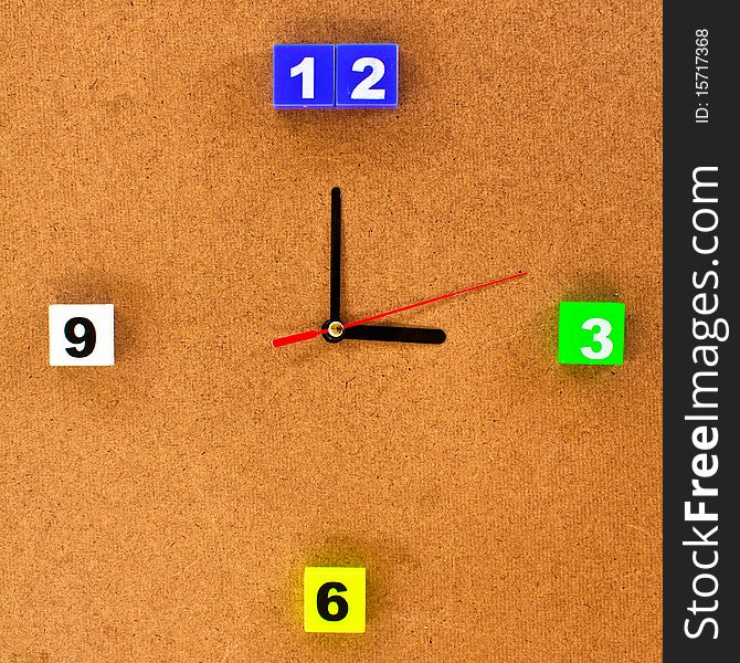 Colorful clock isolated on brown wood board