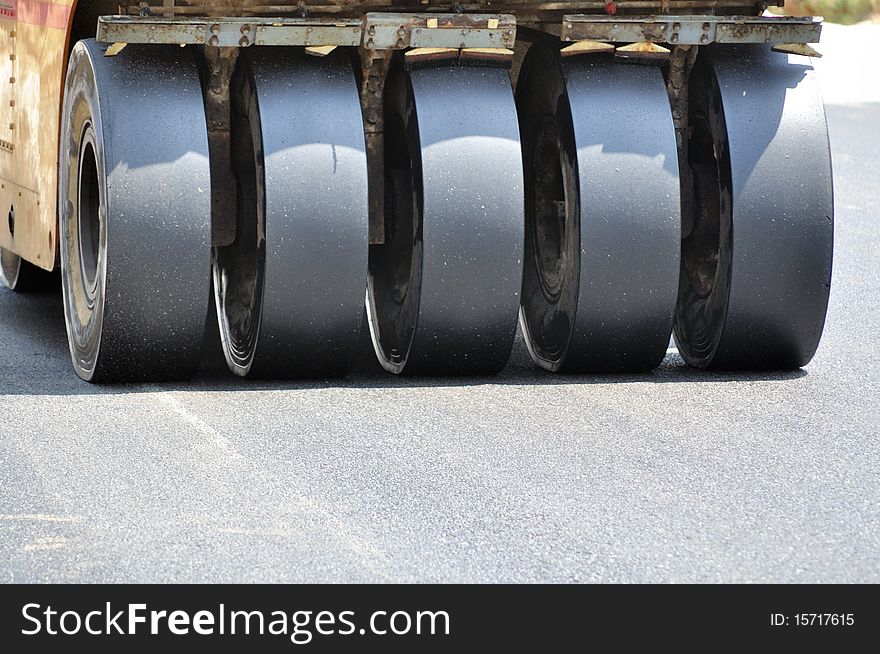 Road roller leveling fresh asphalt pavement