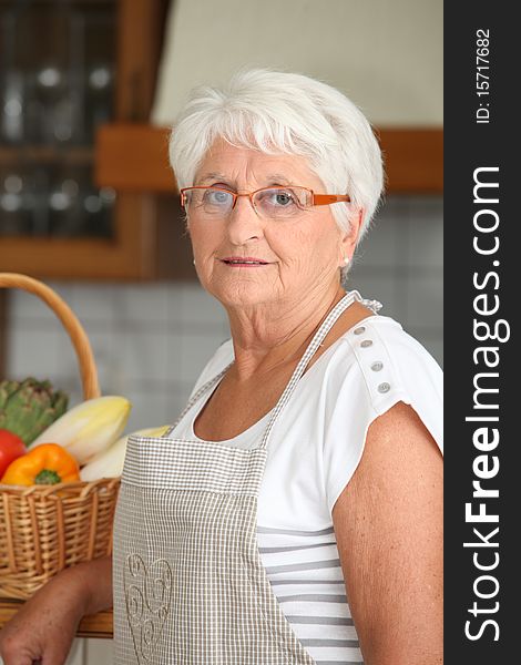 Elderly woman cooking in kitchen. Elderly woman cooking in kitchen