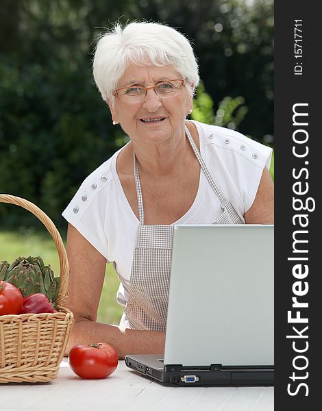 Closeup of elderly woman in garden with basket of fresh vegetables. Closeup of elderly woman in garden with basket of fresh vegetables