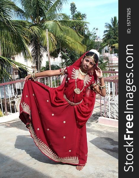 Indian girl in red dress sporting dance posture. Indian girl in red dress sporting dance posture