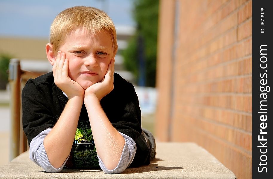 A young boy poses for photographs outside an urban building.