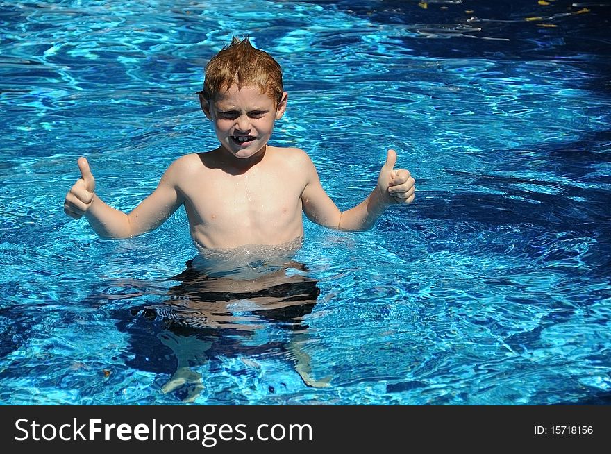 A young boy enjoys playing in the pool on a summer day.