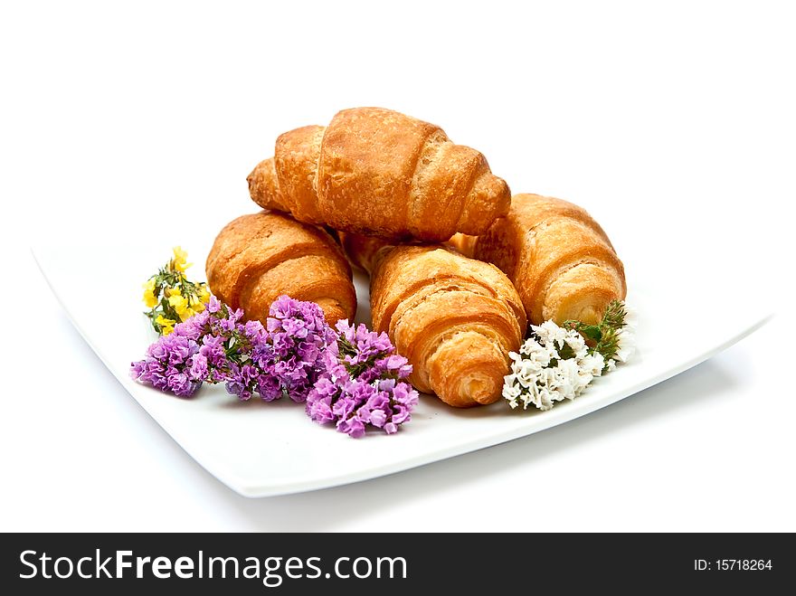 Croissants on plate with flowers isolated on white background. Croissants on plate with flowers isolated on white background