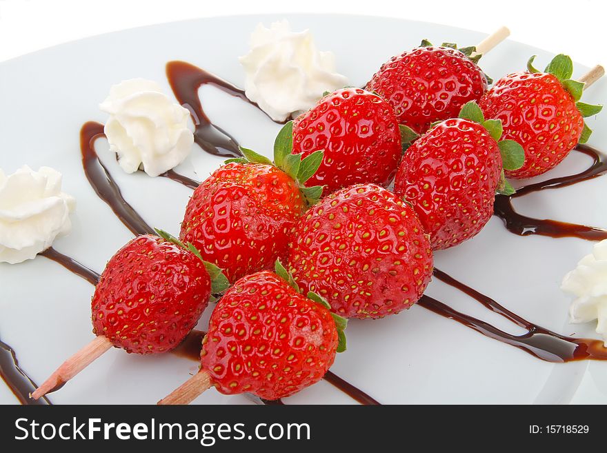 Two sweet skewers strawberry on plate. Two sweet skewers strawberry on plate