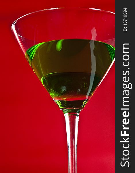 Green drinks in martini glass on red background