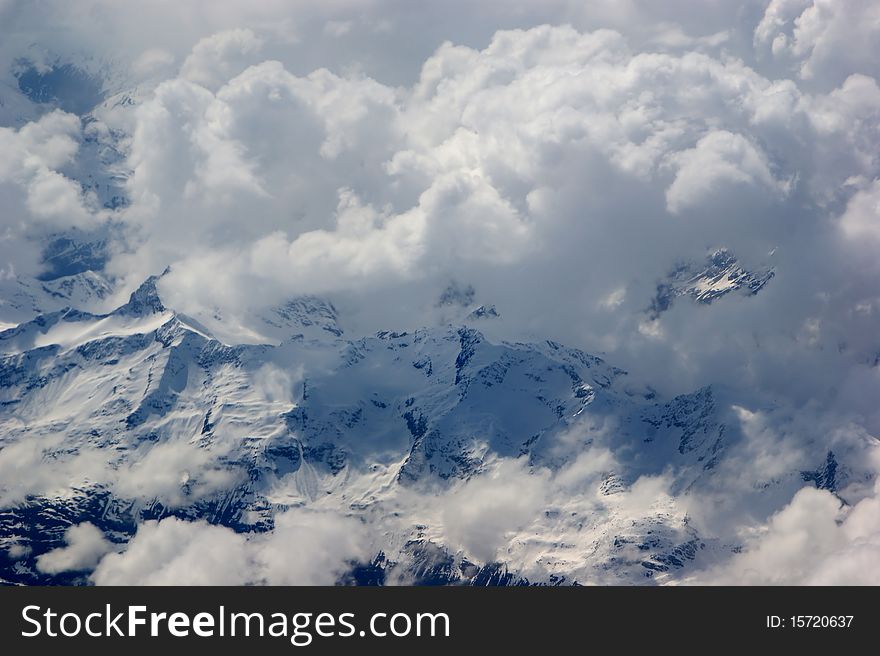 Aerial view of the mighty mountains and the white clouds. Image taken from a very high spot. Aerial view of the mighty mountains and the white clouds. Image taken from a very high spot.