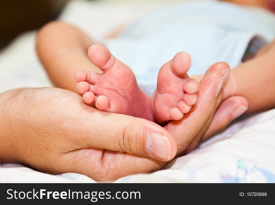 Baby's feet on mom's hand
