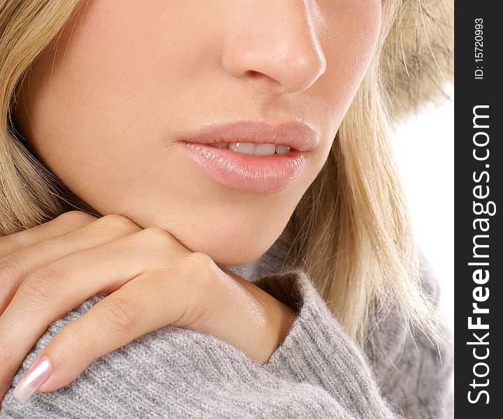 Close-up image of a young blond girl in a gray sweater. The image is isolated on a white background.