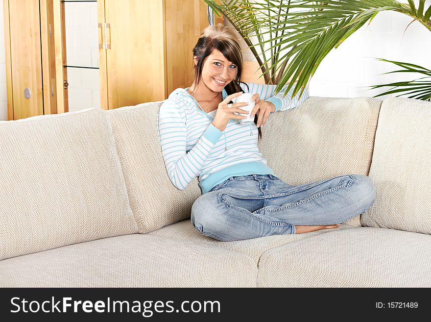 Woman in living room with coffee is smiling. Woman in living room with coffee is smiling