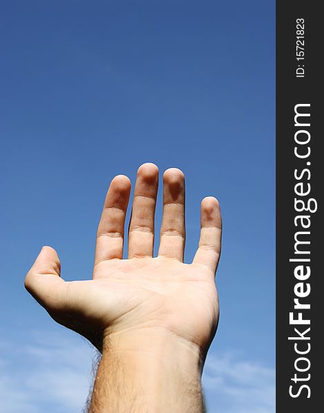 Hand holding something on the blue sky background