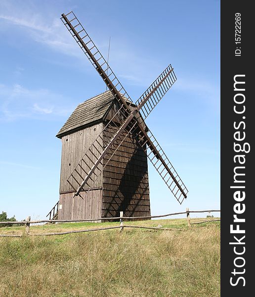 Antique trestle type Windmill (from 1821) in a field with a fence