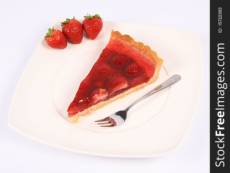 Piece of Strawberry Tart on a plate decorated with strawberries, and a fork