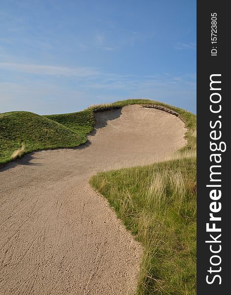 A severe bunker with a steep face. A severe bunker with a steep face