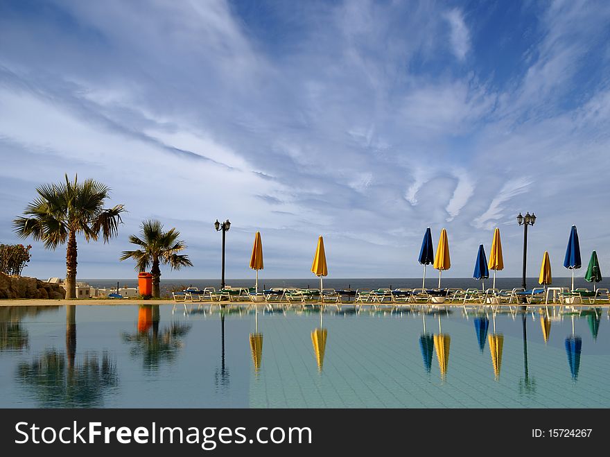 A Resort Image With Sky, Water And Palms