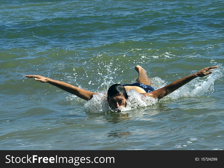 Young funny male swimmer swimming in the sea/ocean