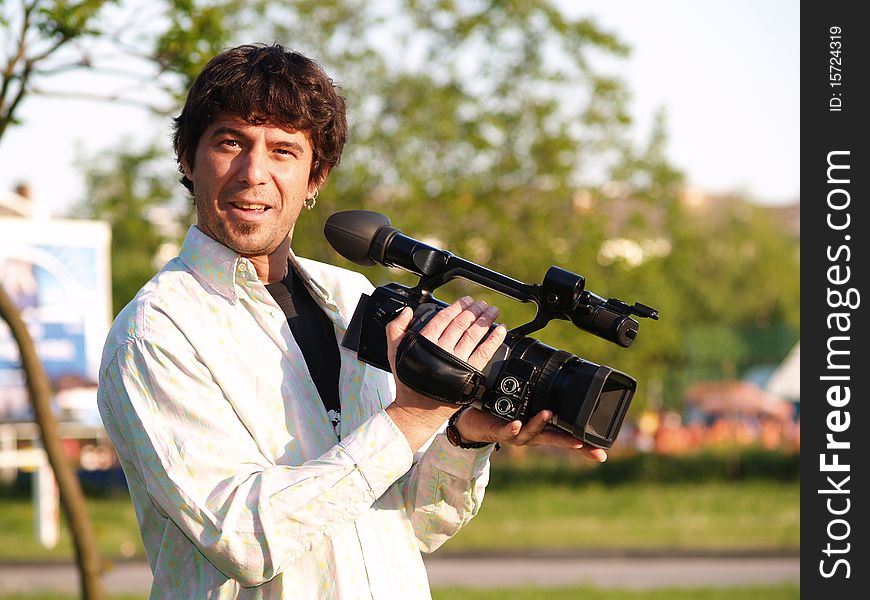 Photographer proudly holding digital camera, looking at the camera. Photographer proudly holding digital camera, looking at the camera