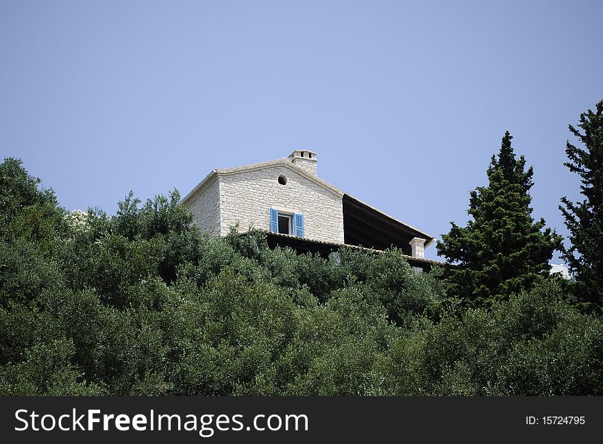 Classic greek villa on a hill in olive wood