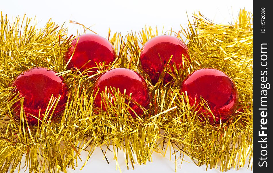 Five red christmas baubles resting on a nest of gold tinsel isolated on white. Five red christmas baubles resting on a nest of gold tinsel isolated on white