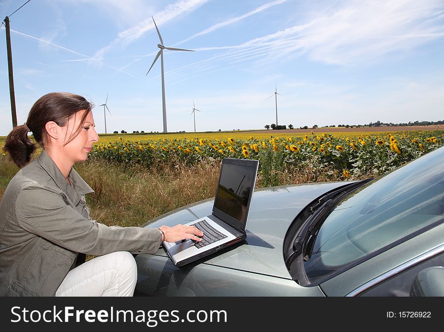Agronomist in sunflowers field with wind turbines. Agronomist in sunflowers field with wind turbines