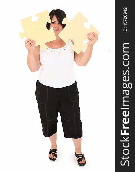 Attractive over weight forty year old french American woman holding two large wooden puzzle pieces over white background. Attractive over weight forty year old french American woman holding two large wooden puzzle pieces over white background.