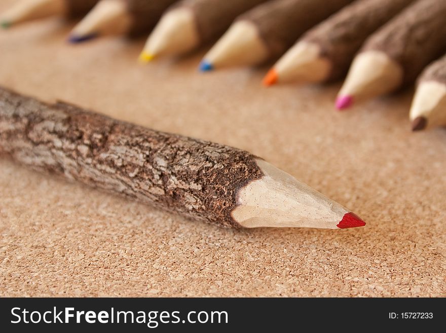 Colored pencils on brown cork background