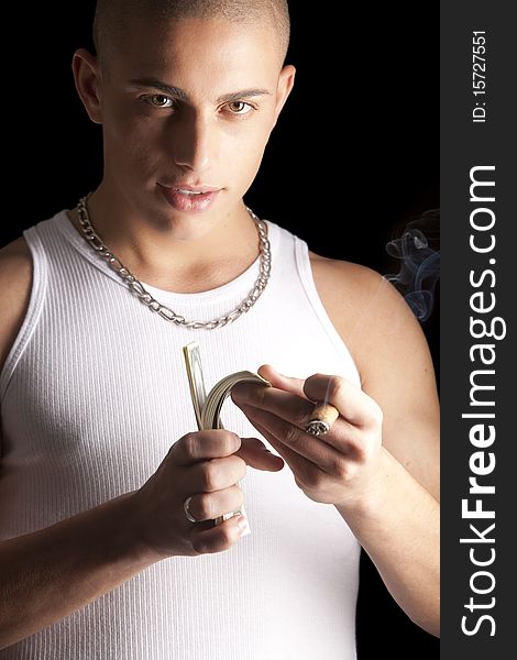 A good looking, muscular built, man on a black background smoking cigar. A good looking, muscular built, man on a black background smoking cigar.