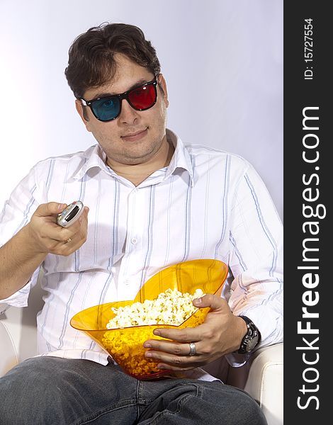 A young man watching a movie in 3D, with stylish 3D glasses and eating popcorn. A young man watching a movie in 3D, with stylish 3D glasses and eating popcorn.