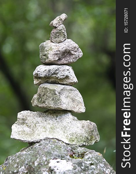 Natural stones arranged in pyramidal form amid the trees
