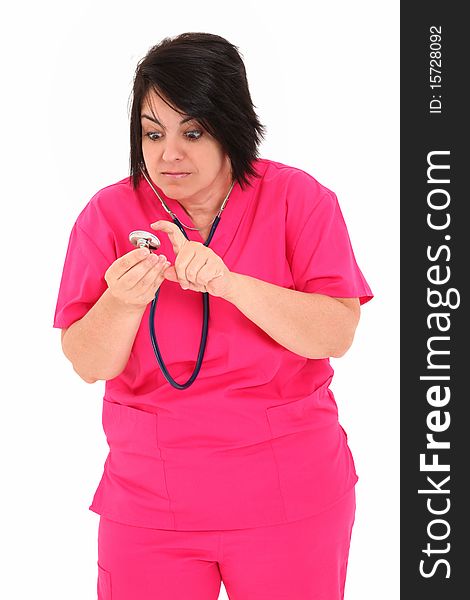 Attractive forty year old over weight nurse in pink scrubs with Stethoscope over white background.  Checking to see if stethoscope works. Attractive forty year old over weight nurse in pink scrubs with Stethoscope over white background.  Checking to see if stethoscope works.