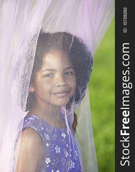 Little girl standing behind canopy with it draped in front of her face. Little girl standing behind canopy with it draped in front of her face