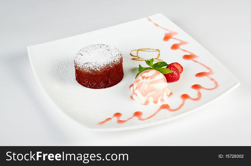 Powdered cupcake with ice cream decorated with jam isolated over white