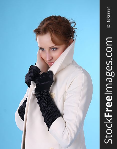 A young woman in a white coat and black gloves cold. A young woman in a white coat and black gloves cold