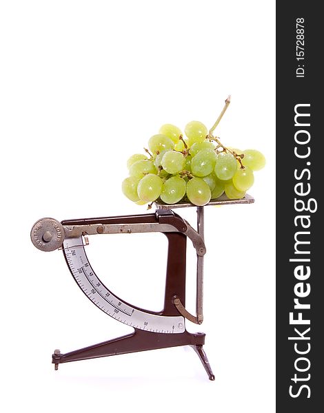 An antiqueted scale with white grapes on top isolate dover white