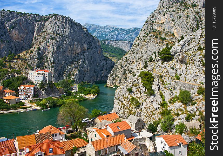 Between the mountains and houses the river flows. Between the mountains and houses the river flows