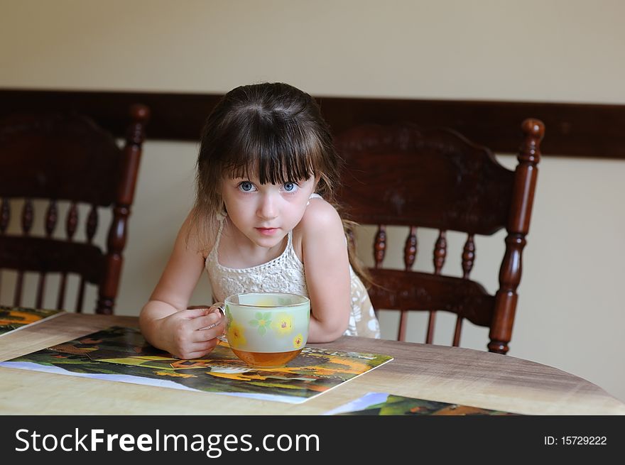 Nice toddler girl with big cup of tea