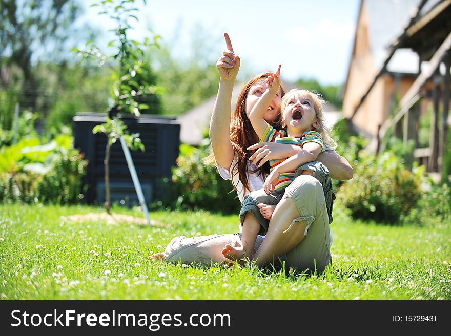 Beautiful young mother with her daughter playing on grass . summer. Beautiful young mother with her daughter playing on grass . summer.