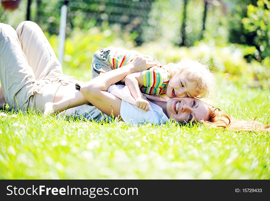 Beautiful young mother with her  daughter playing on grass . summer. Beautiful young mother with her  daughter playing on grass . summer.