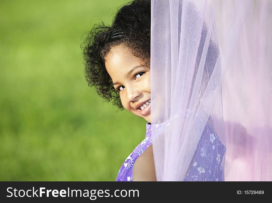 Little girl peeking from behind a canopy, outside. Little girl peeking from behind a canopy, outside