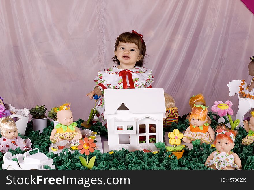 Baby girl playing with a doll house. Baby girl playing with a doll house