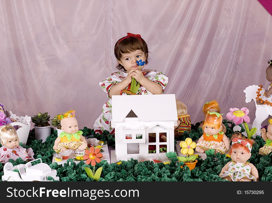 Baby girl playing with a doll house. Baby girl playing with a doll house