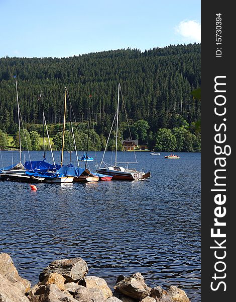 Yachts on a mooring on coast of small picturesque lake. Yachts on a mooring on coast of small picturesque lake