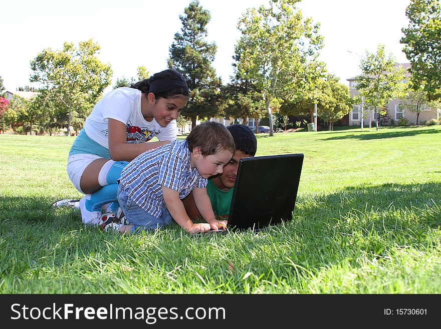 Children in the park with a laptop computer. Children in the park with a laptop computer