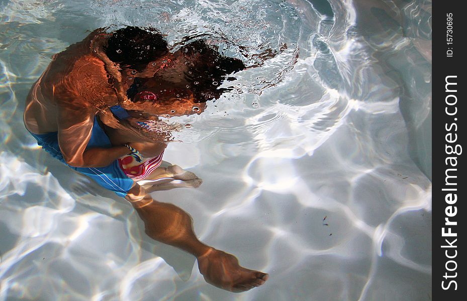 A couple share an intimate kiss underwater. A couple share an intimate kiss underwater