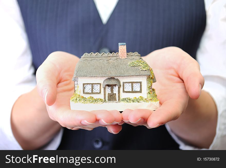 Little house in womans hands in studio