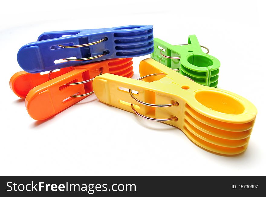 Four colorful clothes pegs on white background