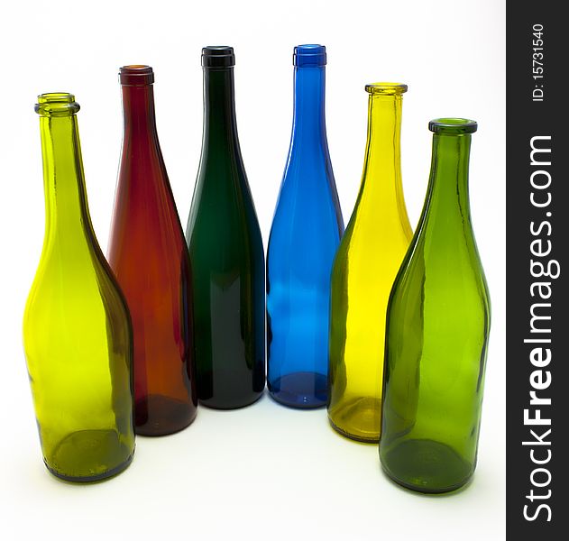 A collection of colorful empty glass wine bottles arranged in a half-circle. A collection of colorful empty glass wine bottles arranged in a half-circle.