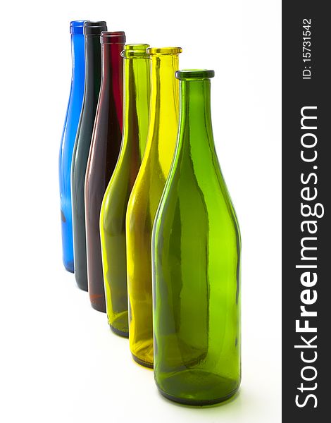 A collection of colorful glass wine bottles arranged in a line. A collection of colorful glass wine bottles arranged in a line.