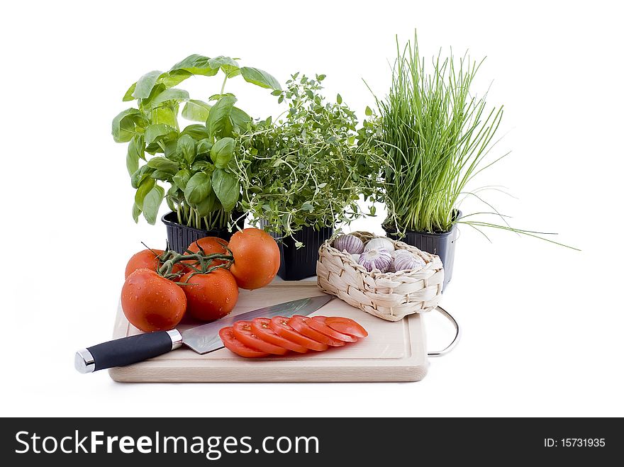 Herbs with chopping board of tomato and garlic