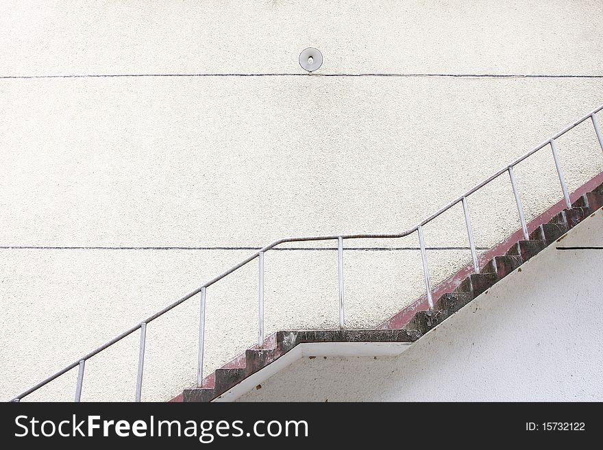 Closeup of concrete stairway with brick stairs and stucco walls